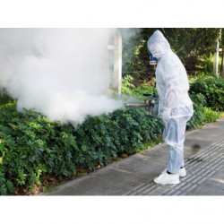 Operator in protective gear fogging in street park.