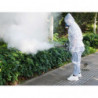 Operator in protective gear fogging in street park.